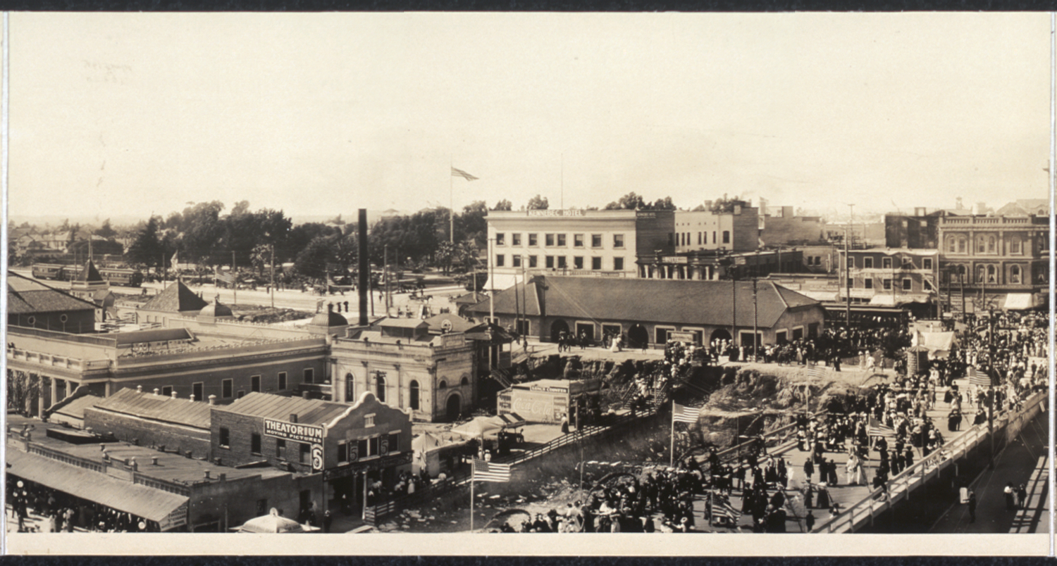 Panel 2 of 3 - A panoramic shot of Long Beach looking north up Pine Avenue and west along the shore, 1908. Before any Port development had begun, beach is all that could be seen. The First National Bank of Long Beach at First Street and Pine Avenue, built in 1906 (seen in Panel 3), is still a familiar landmark today and houses Italian restaurant L'Opera.