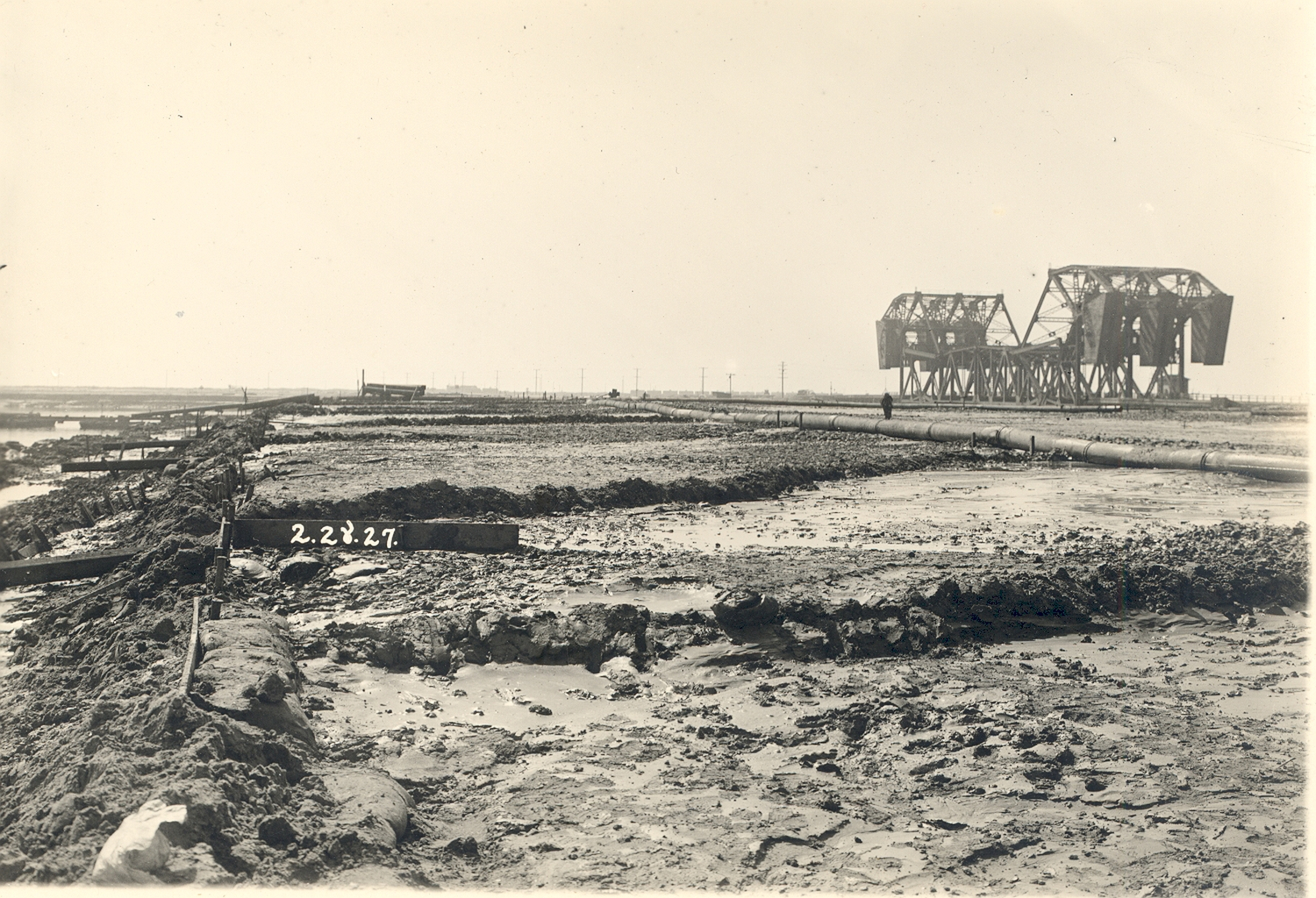 Dredging and other preparatory work is ongoing for the Ford Motor plant in 1927. The plant opened in 1930. At right is the Badger Avenue Bridge (later the Henry Ford Bridge), a railroad drawbridge across the Cerritos Channel. A more modern version of the bridge is still in place.